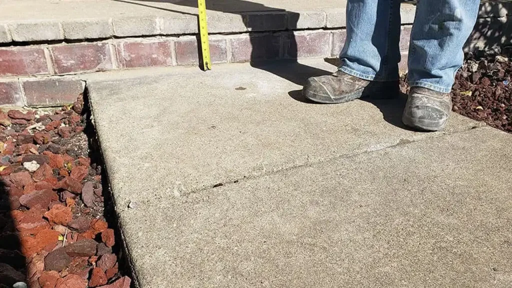 Measuring height difference between uneven concrete slabs for levelling in Boston.